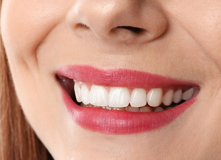 Smiling woman with perfect teeth on white background, closeup